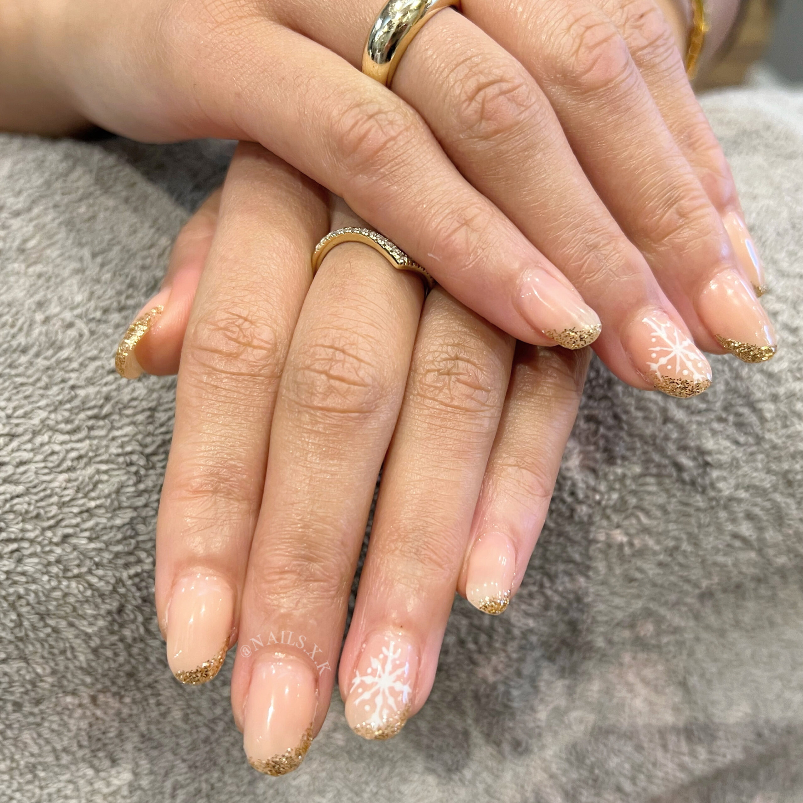 Short hard gel set with a half french gold glitter and snowflake accent designs. Nails by K