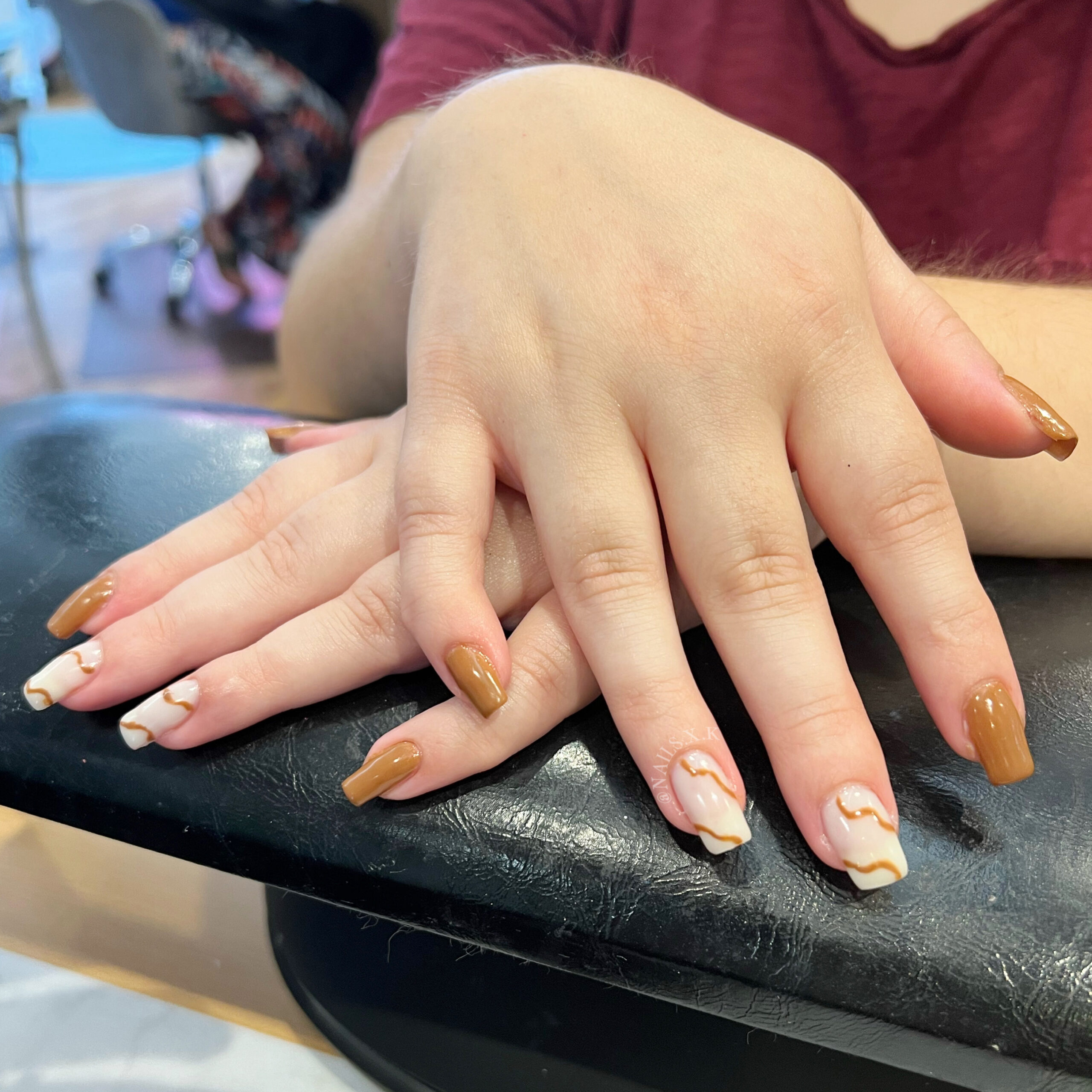 Brown gel manicure with milky white and brown swirl accent nails. Nails by K