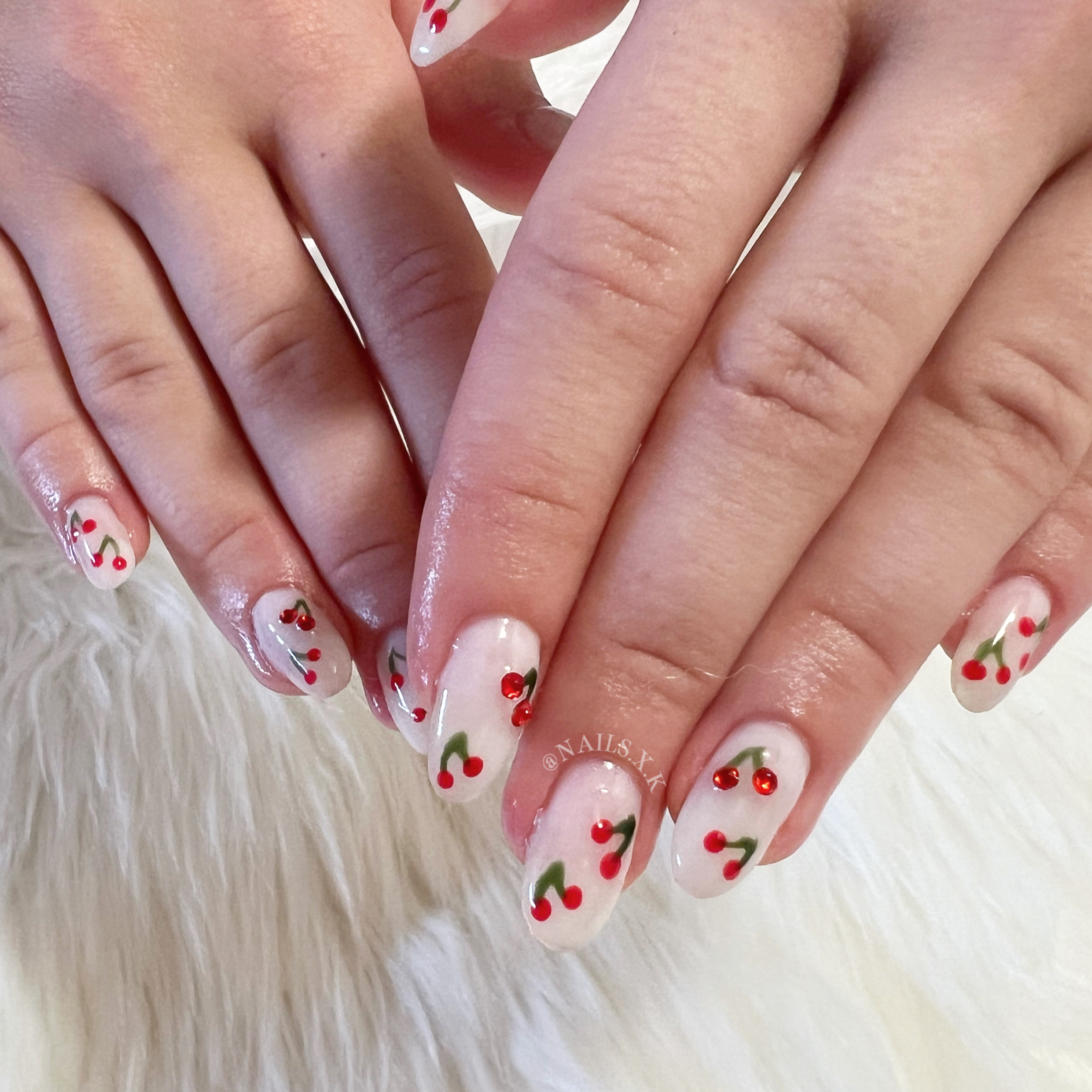 Medium hard gel set with milky white nails and hand-painted cherries on each. Nails by K