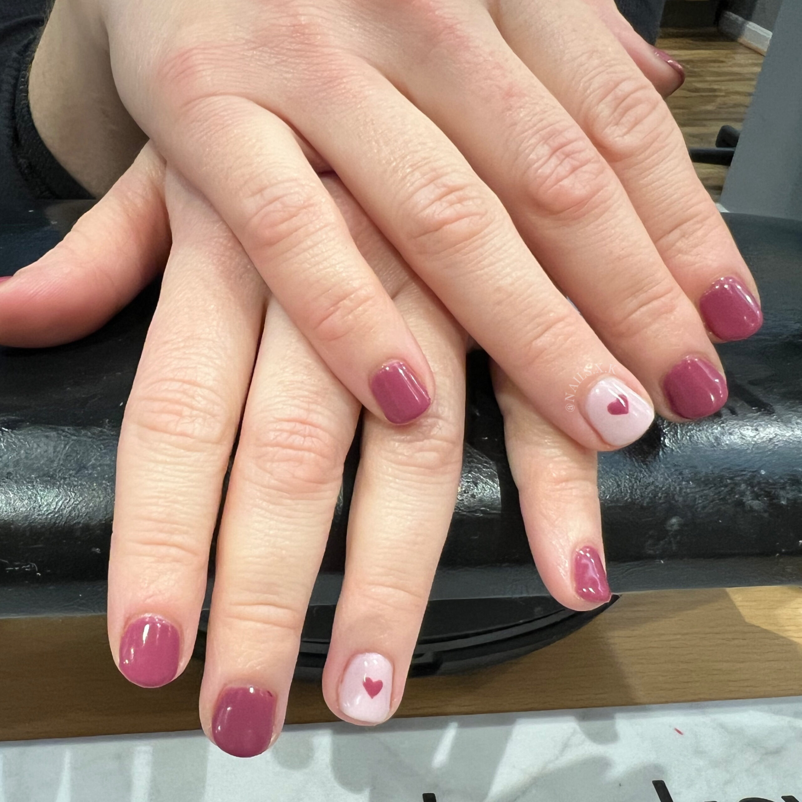 Gel manicure with maroon color accented with pink and hand painted heart. Nails by K