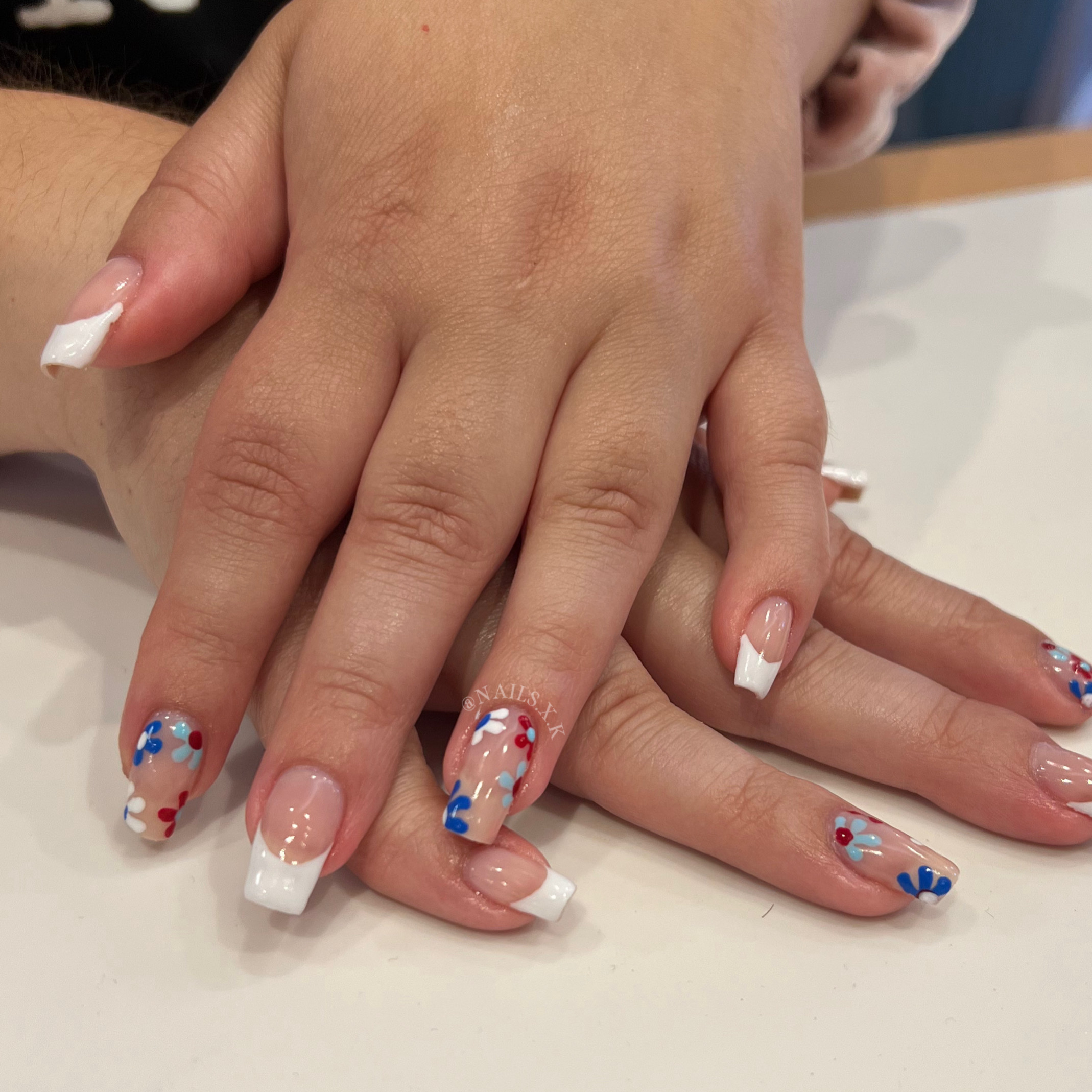 Gel manicure with patriotic hand painted flowers and french designs. Nails by K