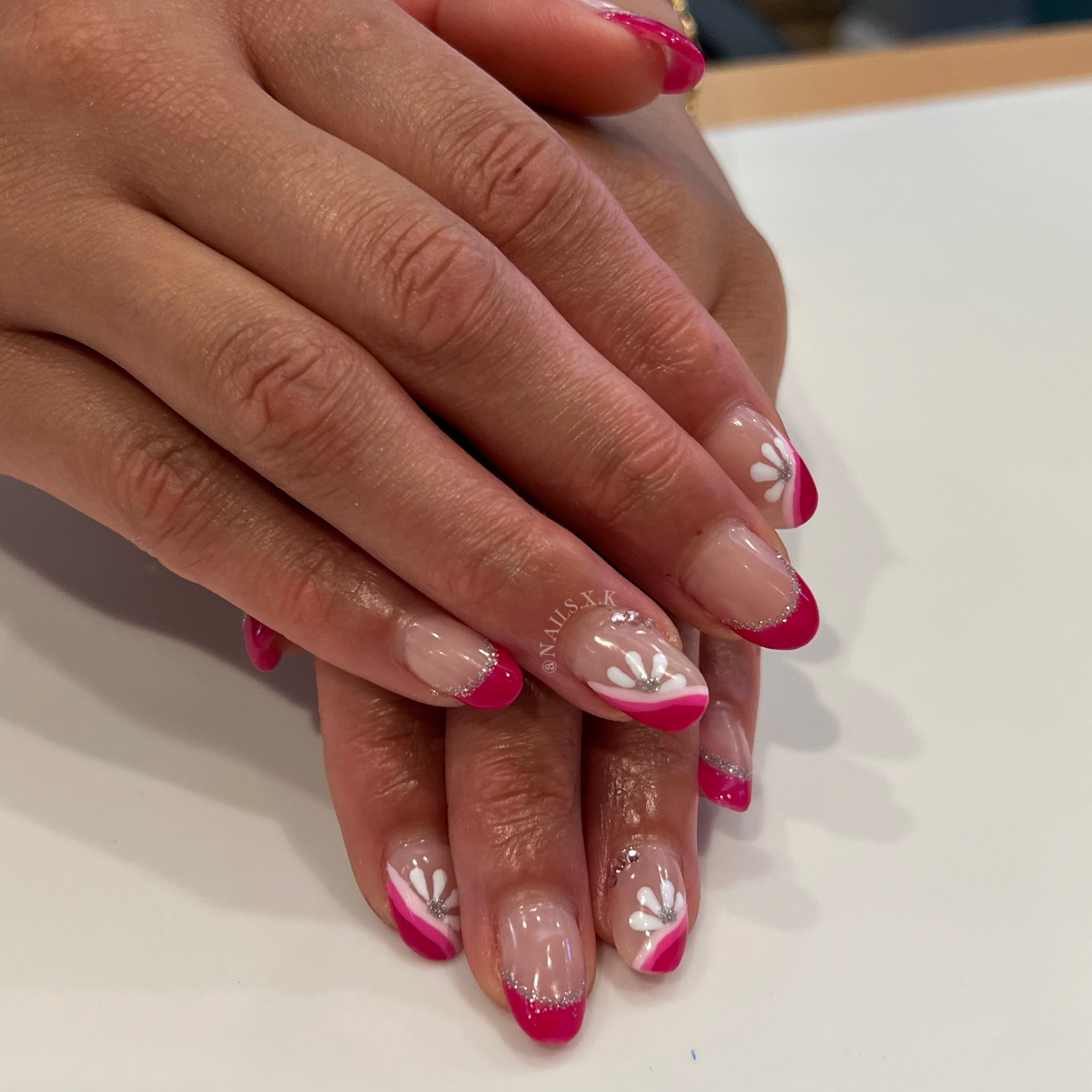 Hard gel nails with pink art and flowers.