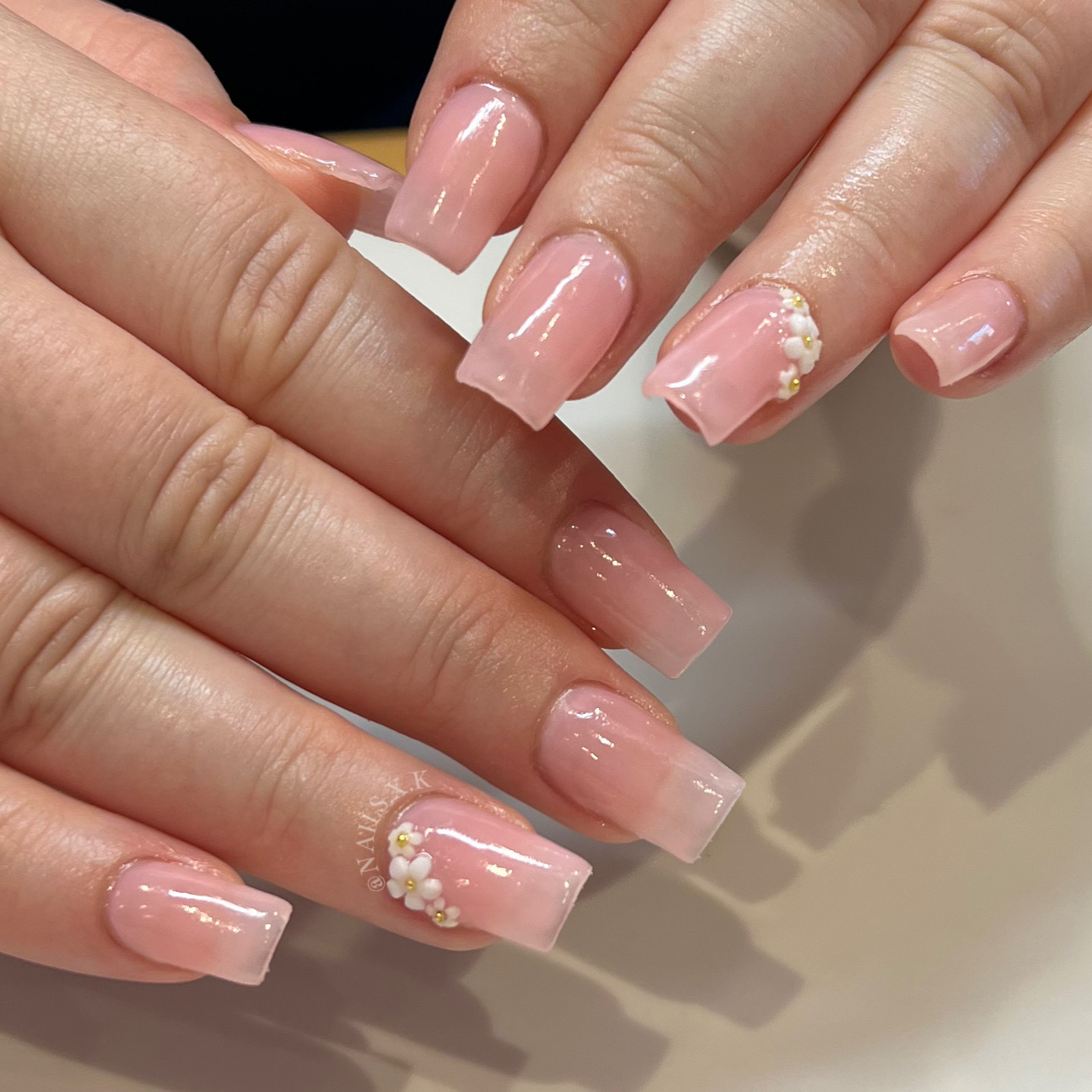 Nude acrylic fill with flower charm accents. Nails by K