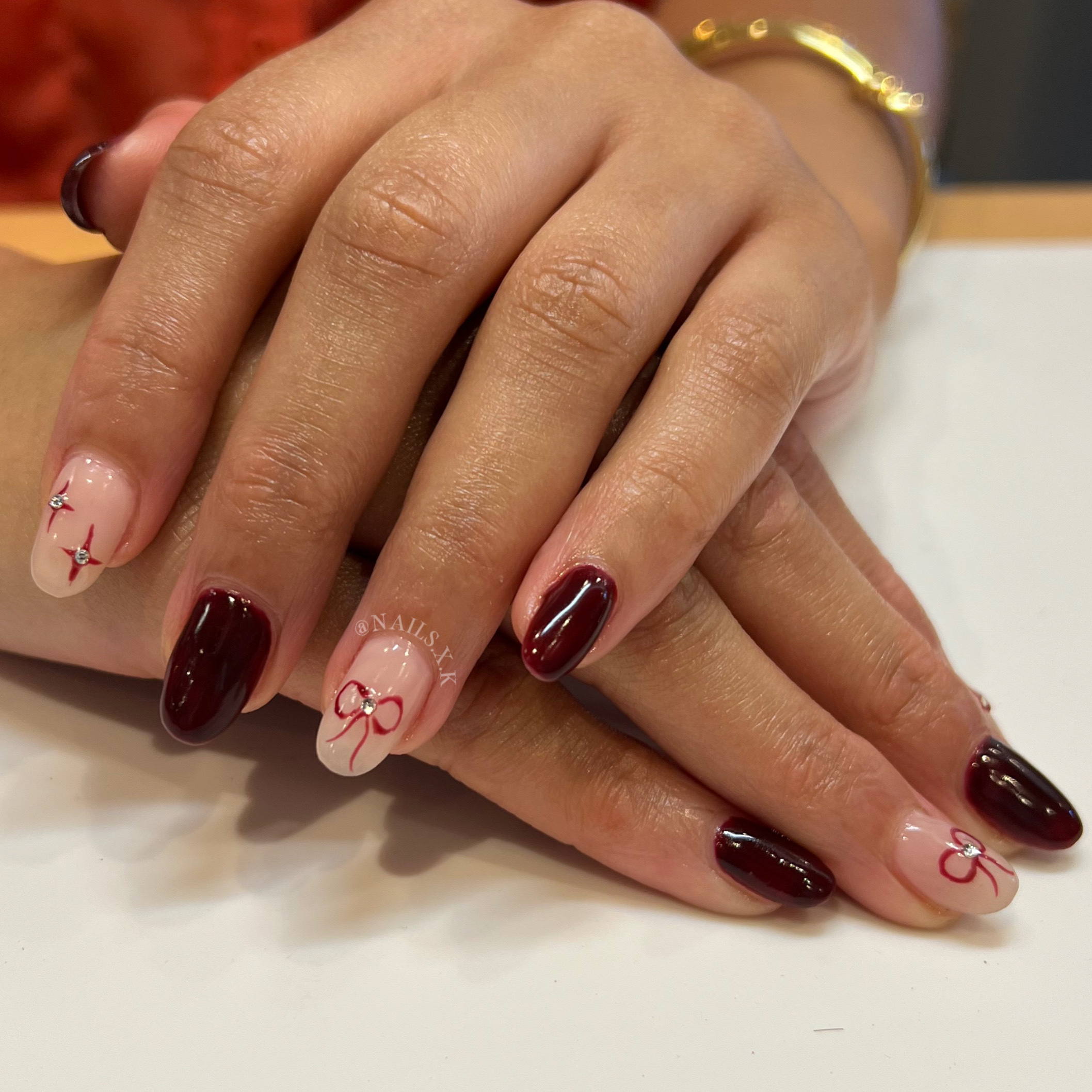 Hard gel fill with a deep red/brown color and hand painted art. Nails by K