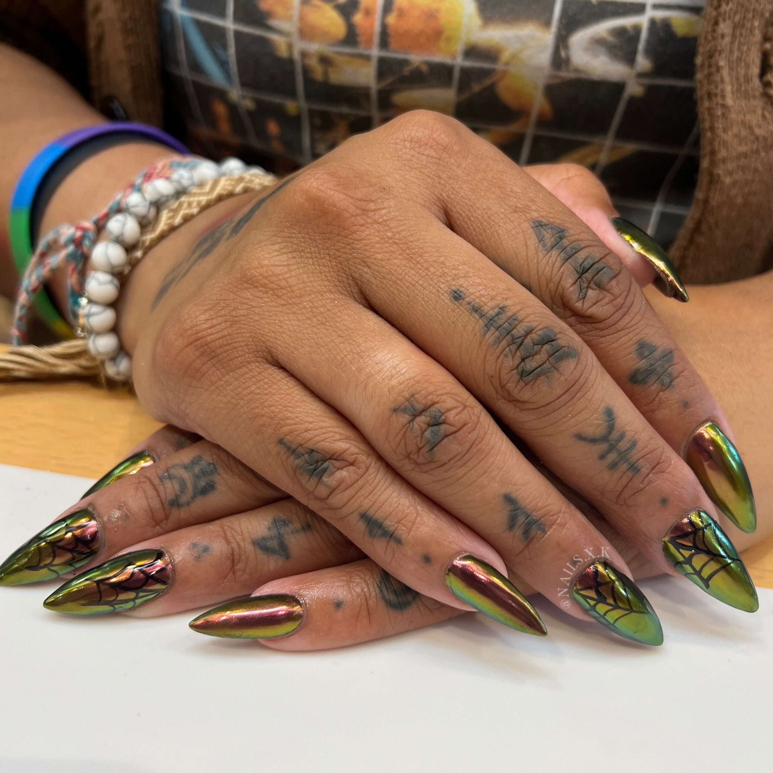 Acrylic nails with oil-slick chrome and hand painted spider webs. Nails by K