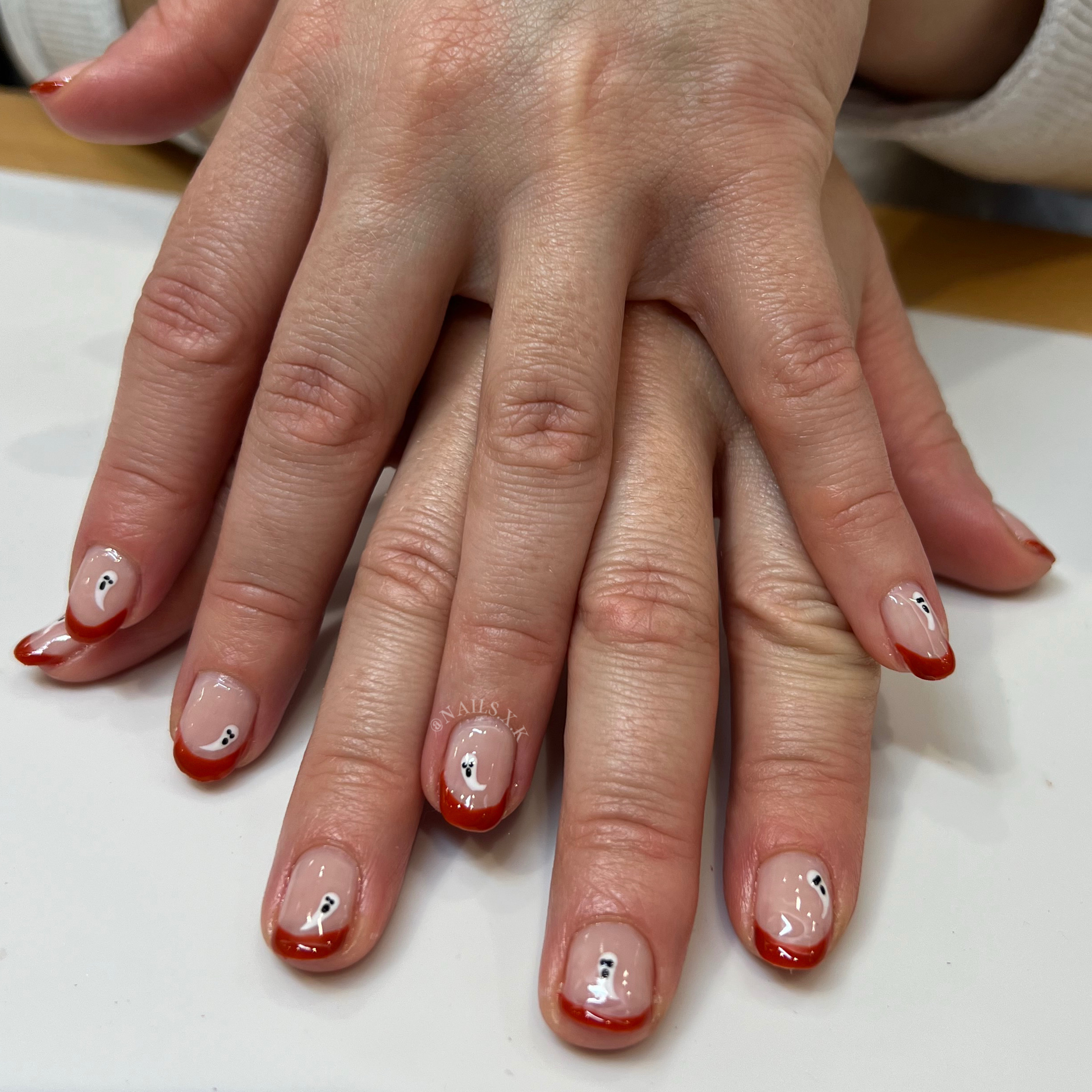 Gel manicure with burnt orange french tips and hand painted ghosts. Nails by K