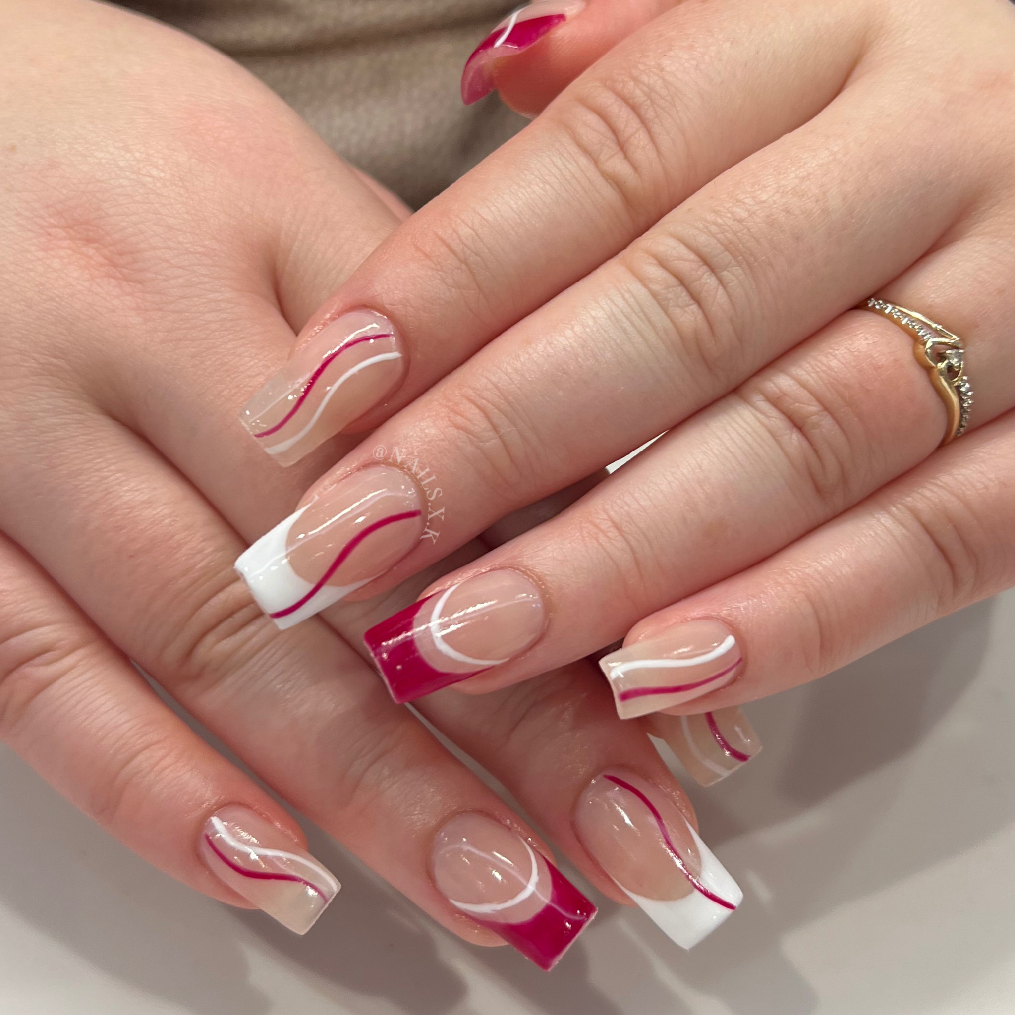 Acrylic nails with red and white hand painted designs. Nails by K