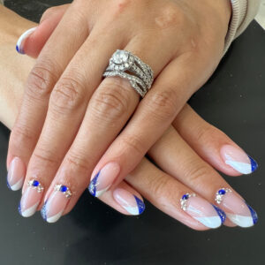 Hard gel nails with a deep blue and white french look accented with rhinestones. Nails by K